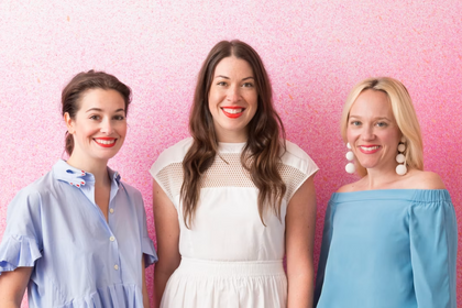 Group portrait of Callie Jenschke, Kim West, and Kristin Gish standing together against a pink background.