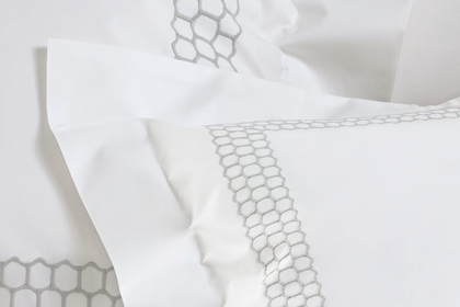 A pillow sham with a honeycomb embroidery pattern.