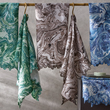 Balthazar marbled napkins in green, brown and blue hanging on a rod.