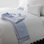 Casablanca light blue pajama set with red piping folded on a bed.