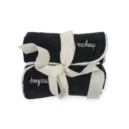 Black Giza makeup remover towel with white piped trim.