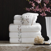 Jasmine Giza white towels with embroidered floral vine border, stacked