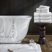 Jasmine Giza white towels draped on a bathtub in a bathroom