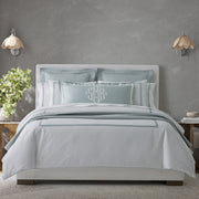 Ambrose bedding in pale seafoam with a flange border and monogrammed pillow, on a bed