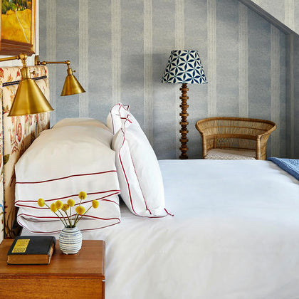 Ansonia white bedding with red border trim styled on a bed