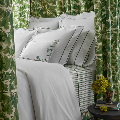 Ansonia bedding with green trim styled under a leafy green canopy