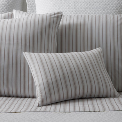 Calypso pinstripe bedding in taupe, shams and a sheet on a bed