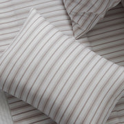 Close-up of Calypso tan striped pillow and matching sheets.
