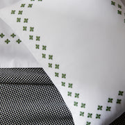 Casablanca Clover white pillow shams styled on a bed with patterned throw.