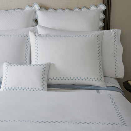 Casablanca embroidered bedding in blue-green styled on a bed