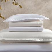 Folded Ceylon percale sheets and pillowcase in white and ivory