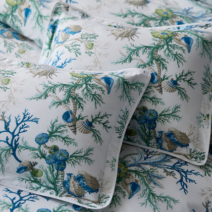 Close-up of blue and green Del Tesoro coral and shell print pillows.