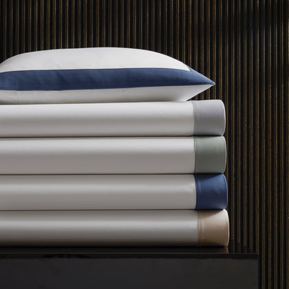 Emory percale sheets and pillowcase stacked with colored border trim