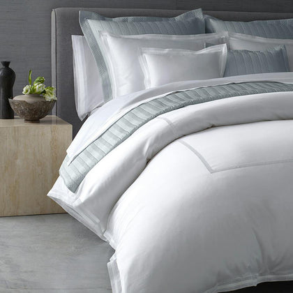 White Grace bedding with gray chevron-quilted shams, styled on a bed.
