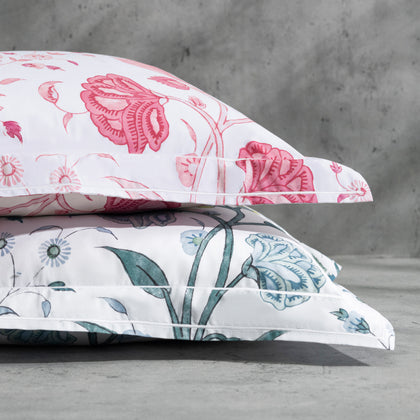 Khilana floral print pillows in pink and blue, stacked.