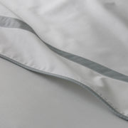 Close-up of white Louise sheets with a light gray ribbon trim.