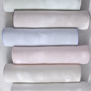 Matteo striped bolster pillows stacked in soft neutral tones