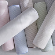 Matteo bolster pillows arranged in a row of soft colors