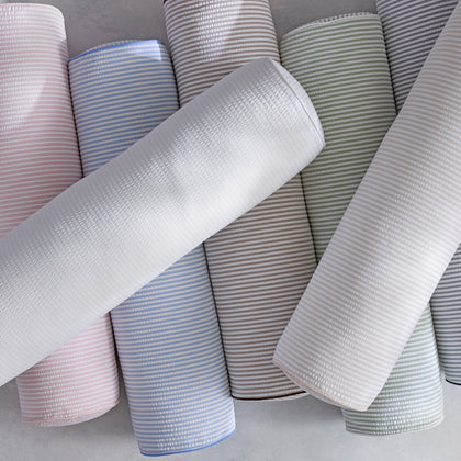 Matteo bolster pillows arranged in a row of soft colors