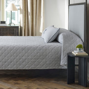 Matteo quilted coverlet in deep navy stripe on a bed.