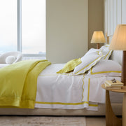Lemon yellow Nocturne bedding and white scalloped shams by a window