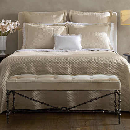 Perla almond matelassé coverlet styled on a bed