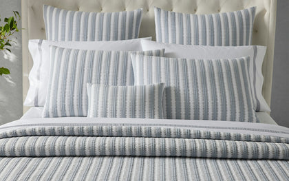 Striped bedding set on a bed with pillows
