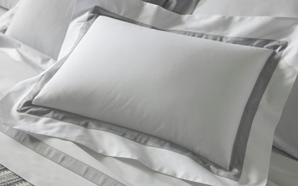 Gray pillowcase on a white pillow with a textured fabric background