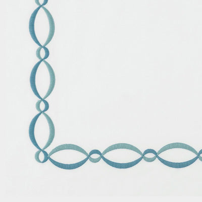 Close up of a napkin with repeating interlocking oval links in a muted blue-green tone on a white background.