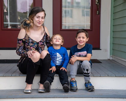 Family sitting together on a porch step, smiling