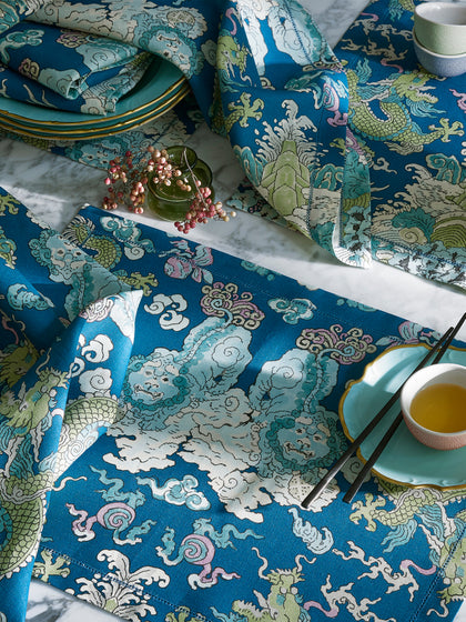 Magic Mountain Tablecloth in blue and green dragon print styled with napkins on marble