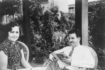 Vintage black-and-white photo of a man and woman seated outdoors on a patio.