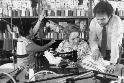 Archival photo of George Matouk overseeing embroiderers in the factory