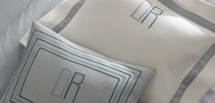 Rectangular nested-line border monogram style on a pillow sham.