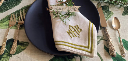 Diagonal three-letter monogram with a double-line border on a napkin.