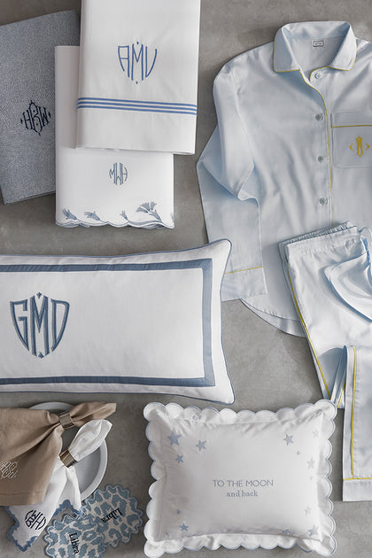 Monogrammed bedding, pillows, and sleepwear styled in soft blue and white tones
