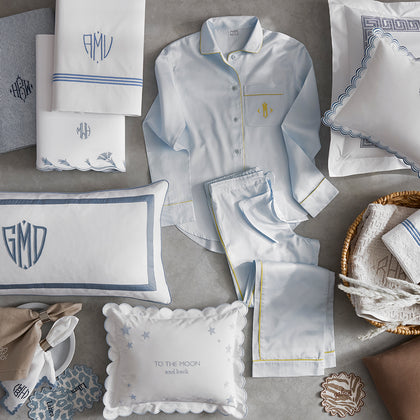 Assortment of monogrammed pajamas, pillows, and linens for personalization.