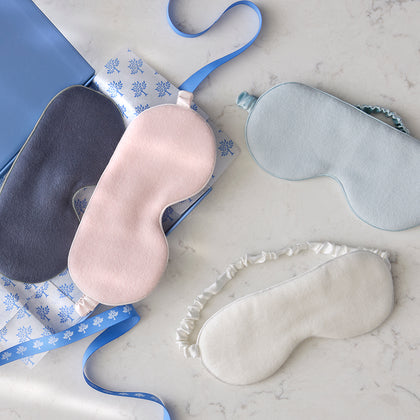 Dream Modal Sleep Masks in blush, ink, pool, and oyster styled on a marble surface