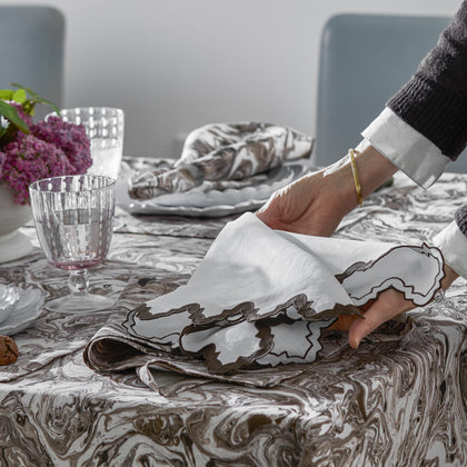 Place setting with Balthazar marbled linens and Aziza scalloped napkins.
