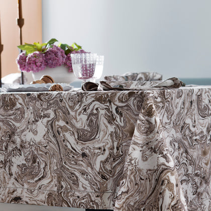 Balthazar marbleized tablecloth with lilacs and a lit candle nearby