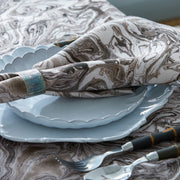 Balthazar marbleized napkin in a ring on a scalloped plate