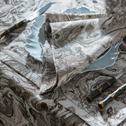 Balthazar marbleized napkin and placemat beside a scalloped plate