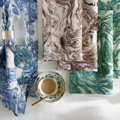 Balthazar marbled napkins in blue, brown and green beside a teacup.