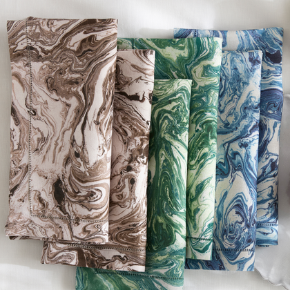 Schumacher Matouk Balthazar napkins folded in brown, green, and blue tones