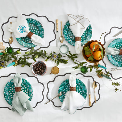 Calypso scalloped placemats with teal plates styled as a table setting.