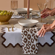 Setting a table with brown Iconic Leopard napkins and scalloped placemats