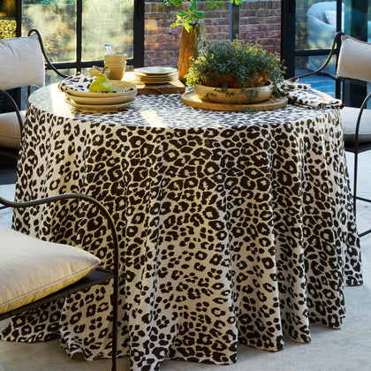 Brown Iconic Leopard print tablecloth set on an outdoor patio table with yellow china.
