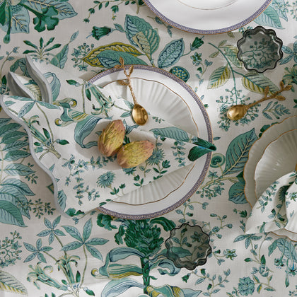 Green Pomegranate botanical print tablecloth set with greek-key bordered plates and artichokes.