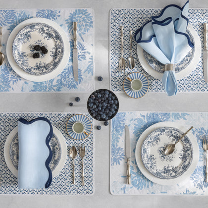 Blue floral reversible placemats set with blue and white china.