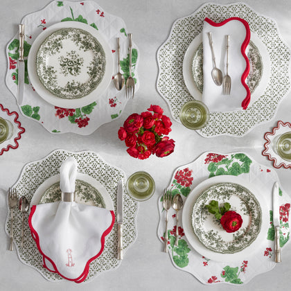 Green floral reversible placemats with red-trimmed white napkins.